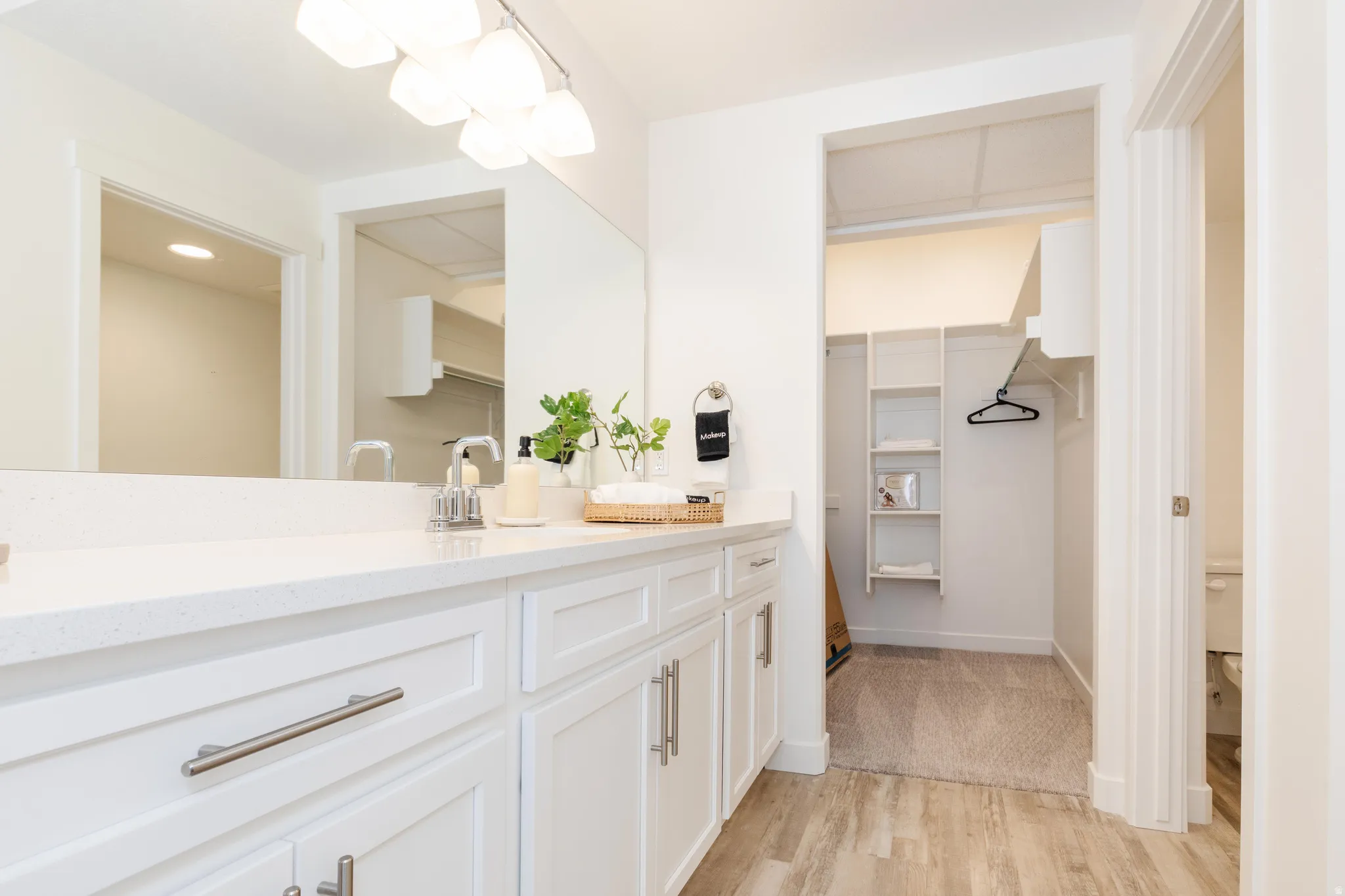 Bathroom featuring a white dual vanity with a light-toned countertop and brushed nickel hardware