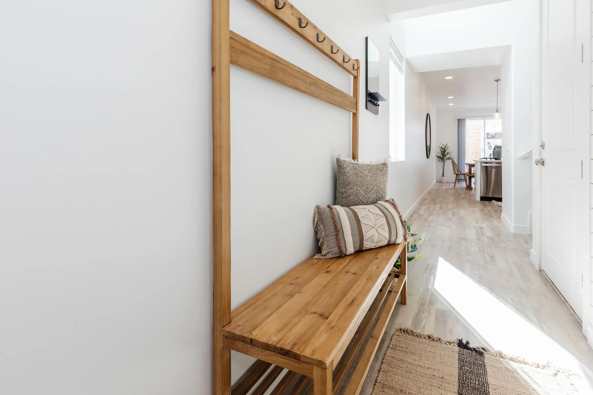 Hallway featuring light wood-finish flooring, white walls, and recessed lighting