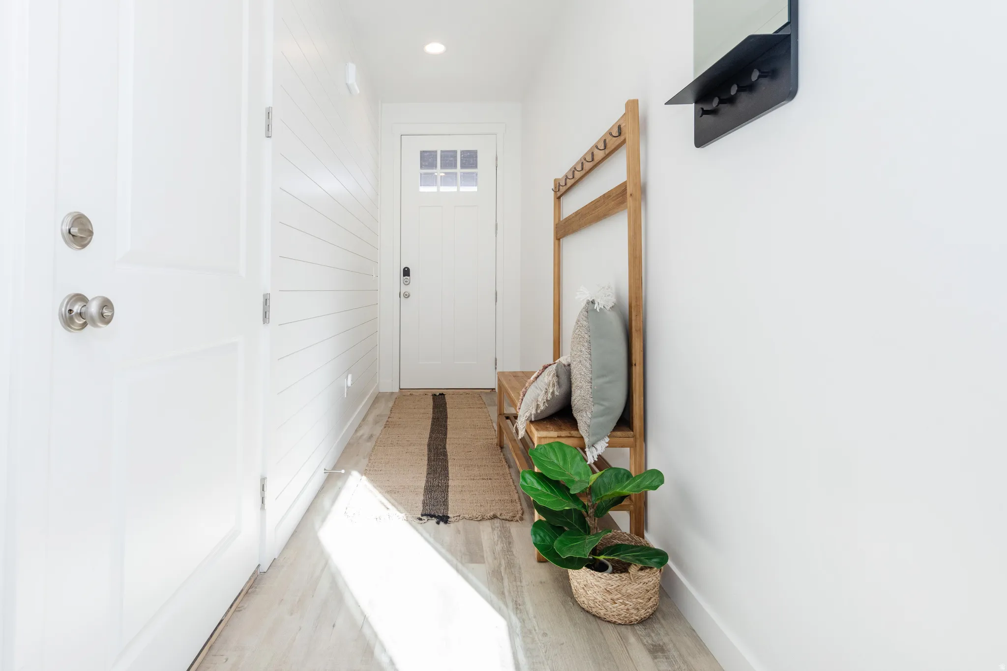 Entryway featuring crisp white walls, wood-finish flooring, recessed lighting, and a front door with divided lites