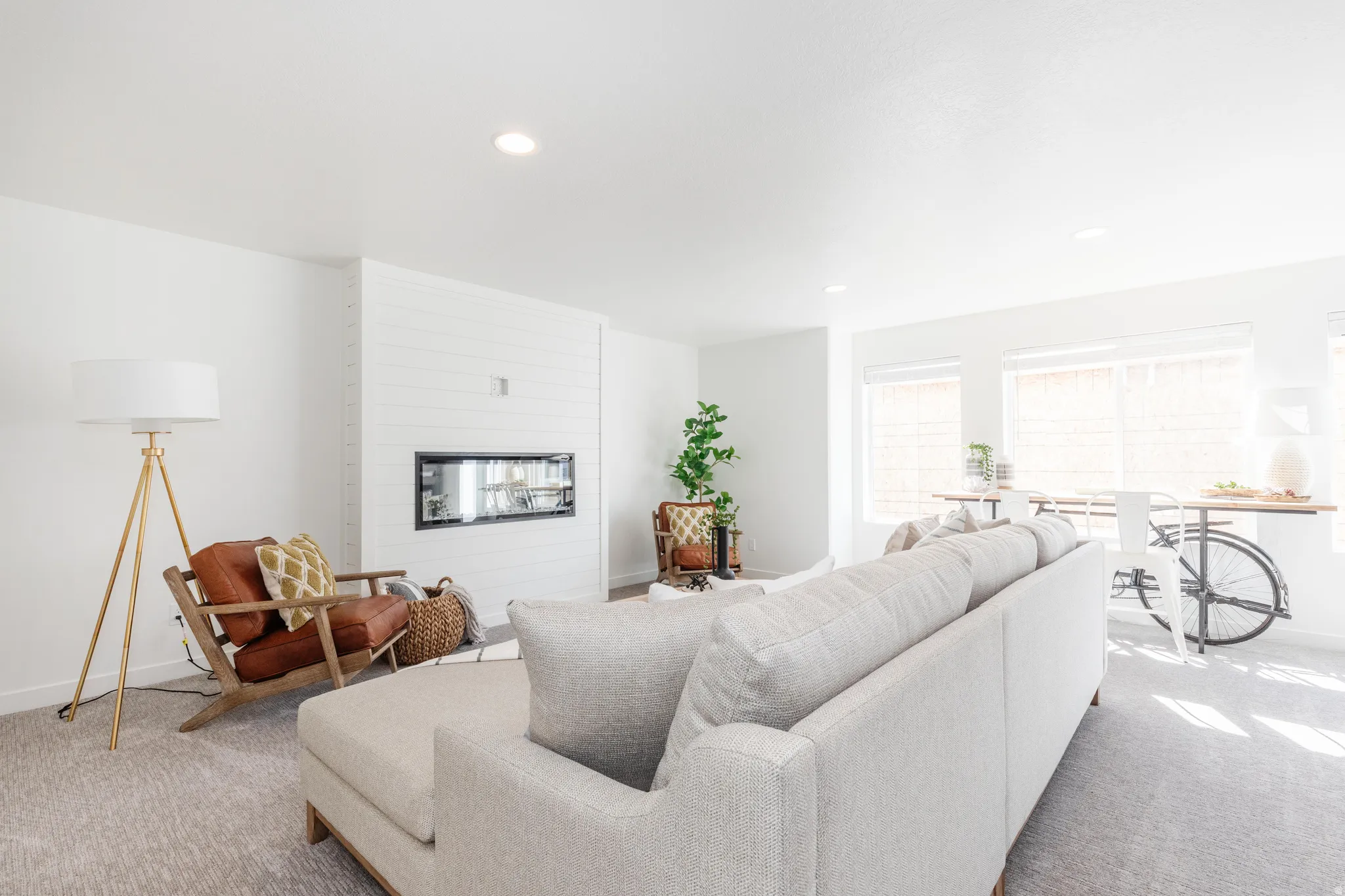 Contemporary living area featuring a built-in linear fireplace, recessed lighting, and light-toned carpeting