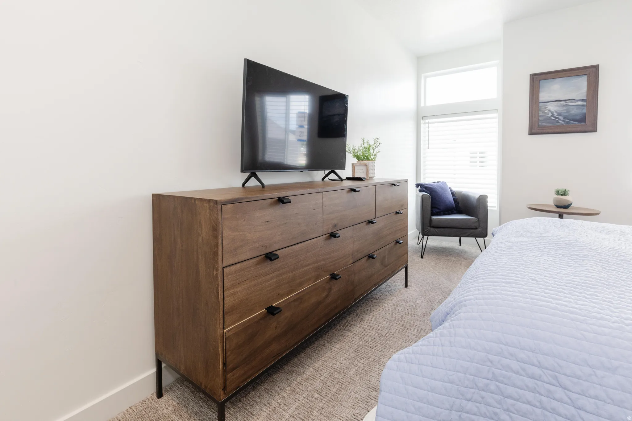 Bedroom featuring a large window with blinds, light-colored walls, and carpeting