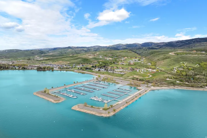 Expansive marina with numerous boat slips, set against a backdrop of rolling hills and a vibrant blue lake