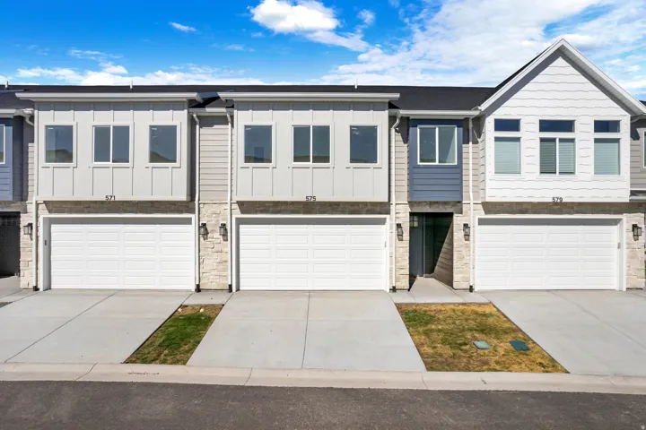 Modern townhome exteriors featuring horizontal siding, vertical board and batten accents, and stone veneer detailing