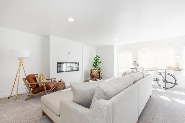 Contemporary living area featuring a built-in linear fireplace, recessed lighting, and light-toned carpeting