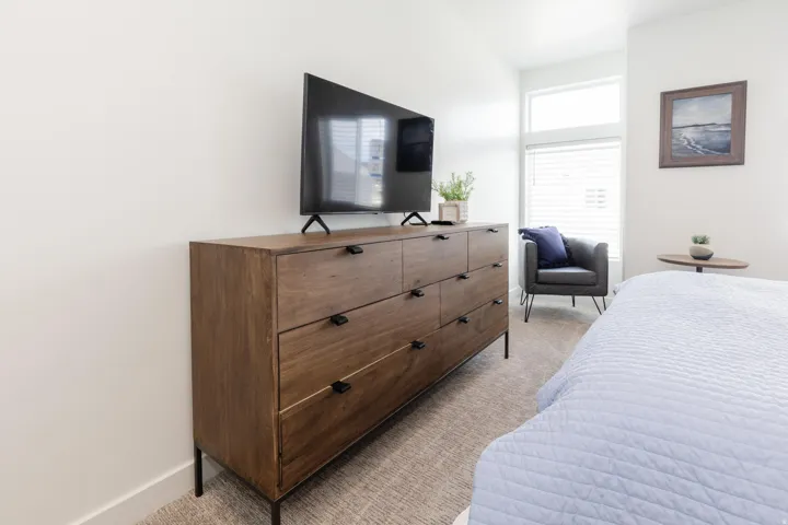 Bedroom featuring a large window with blinds, light-colored walls, and carpeting