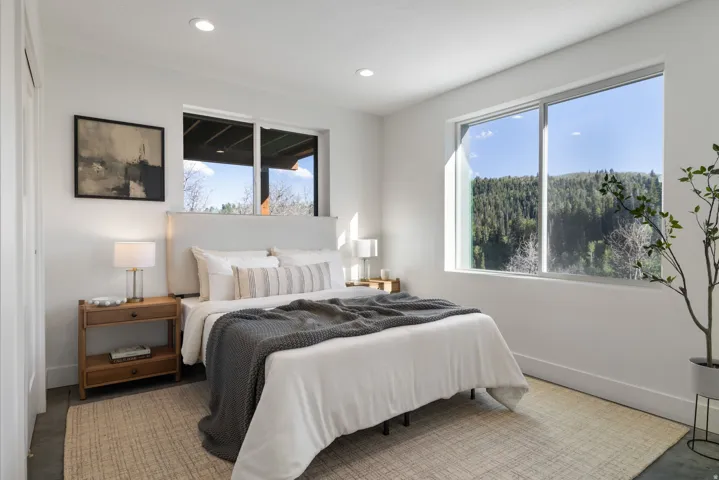 Recessed lighting, large windows, and a textile headboard