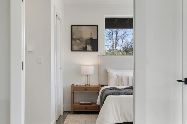 White painted walls, wood-finish flooring, recessed window, and black hardware
