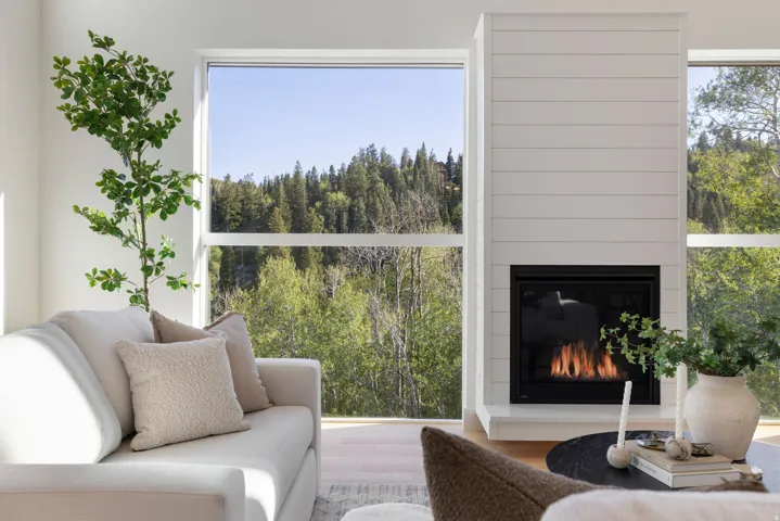 Floor-to-ceiling windows, modern fireplace with shiplap-style surround, and recessed firebox