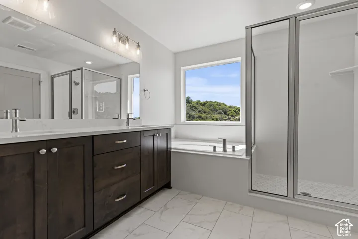 Bathroom featuring a double vanity with dark wood cabinetry, white countertops, and brushed nickel fixtures