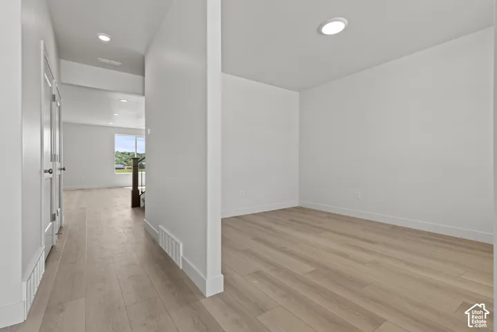 Open concept interior featuring light wood-finish flooring, white walls, and recessed lighting