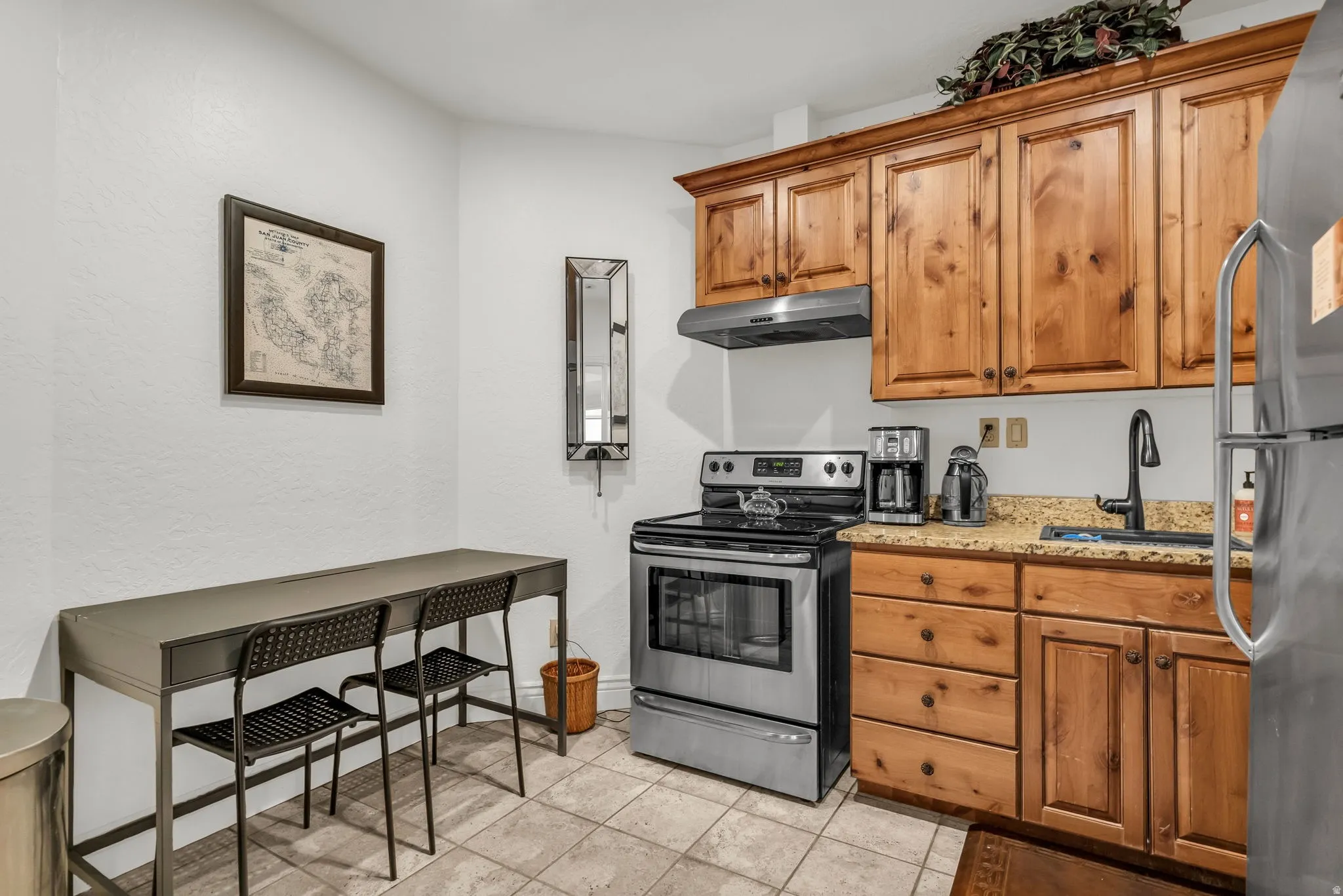 Basement Kitchen featuring knotty pine cabinetry, granite-style countertops