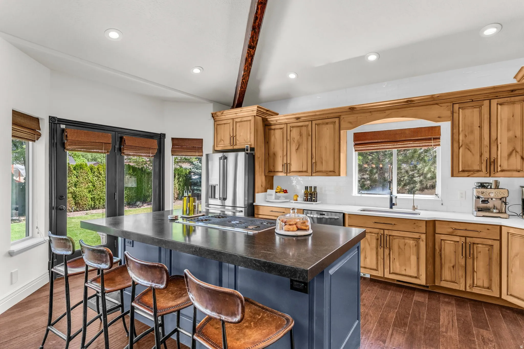 Kitchen featuring wood-finish flooring, natural wood cabinetry, white countertops, and stainless steel appliances