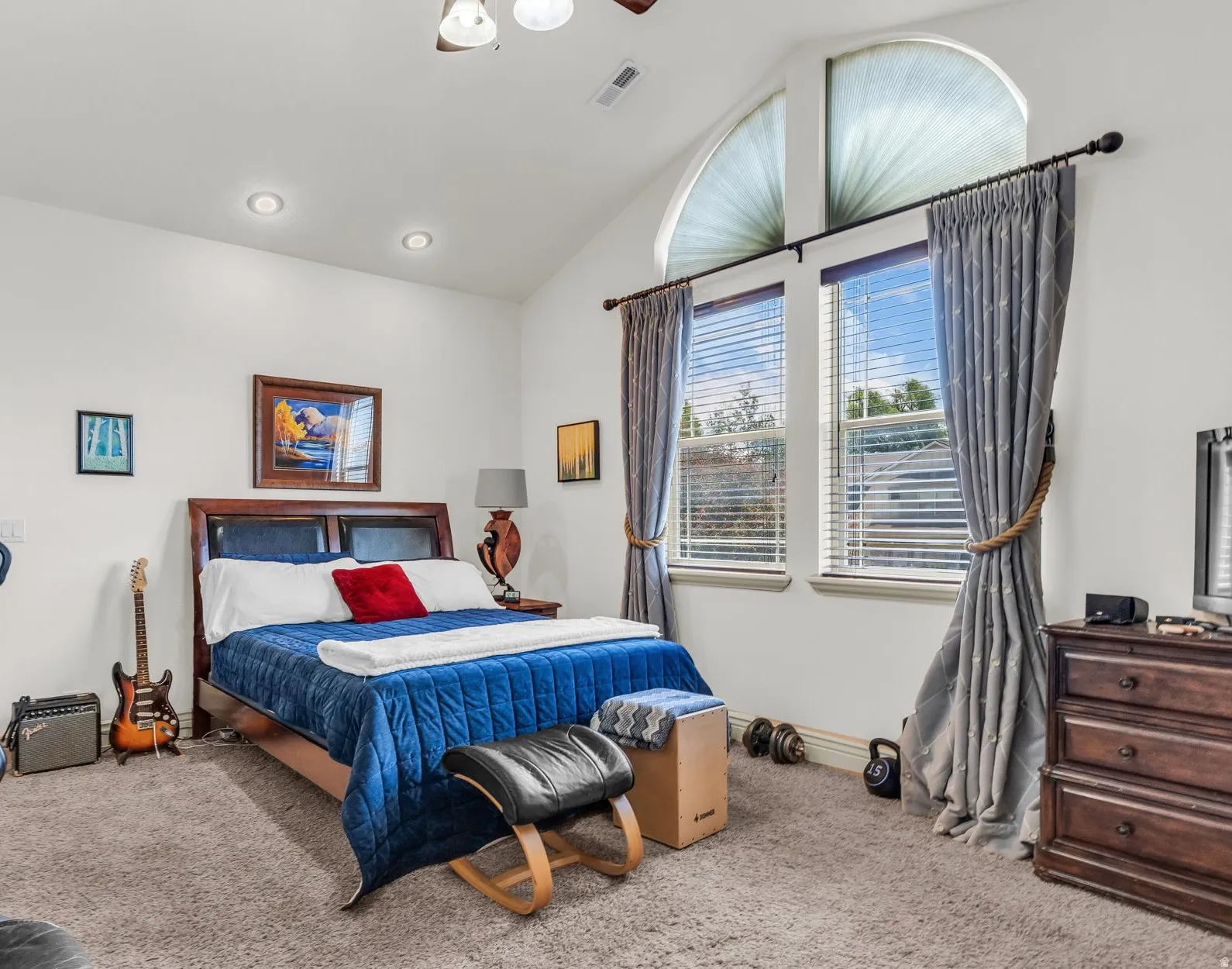 Level 2 master bedroom with vaulted ceilings featuring recessed lighting and an arched transom window.