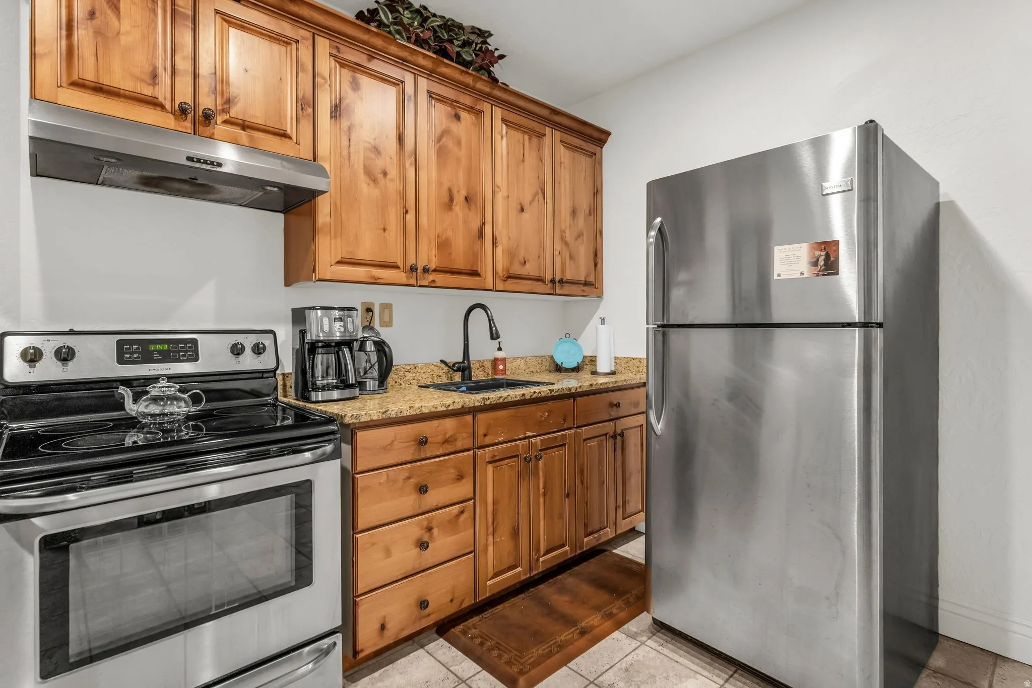 Basement Kitchen featuring knotty pine cabinetry, granite-style countertops