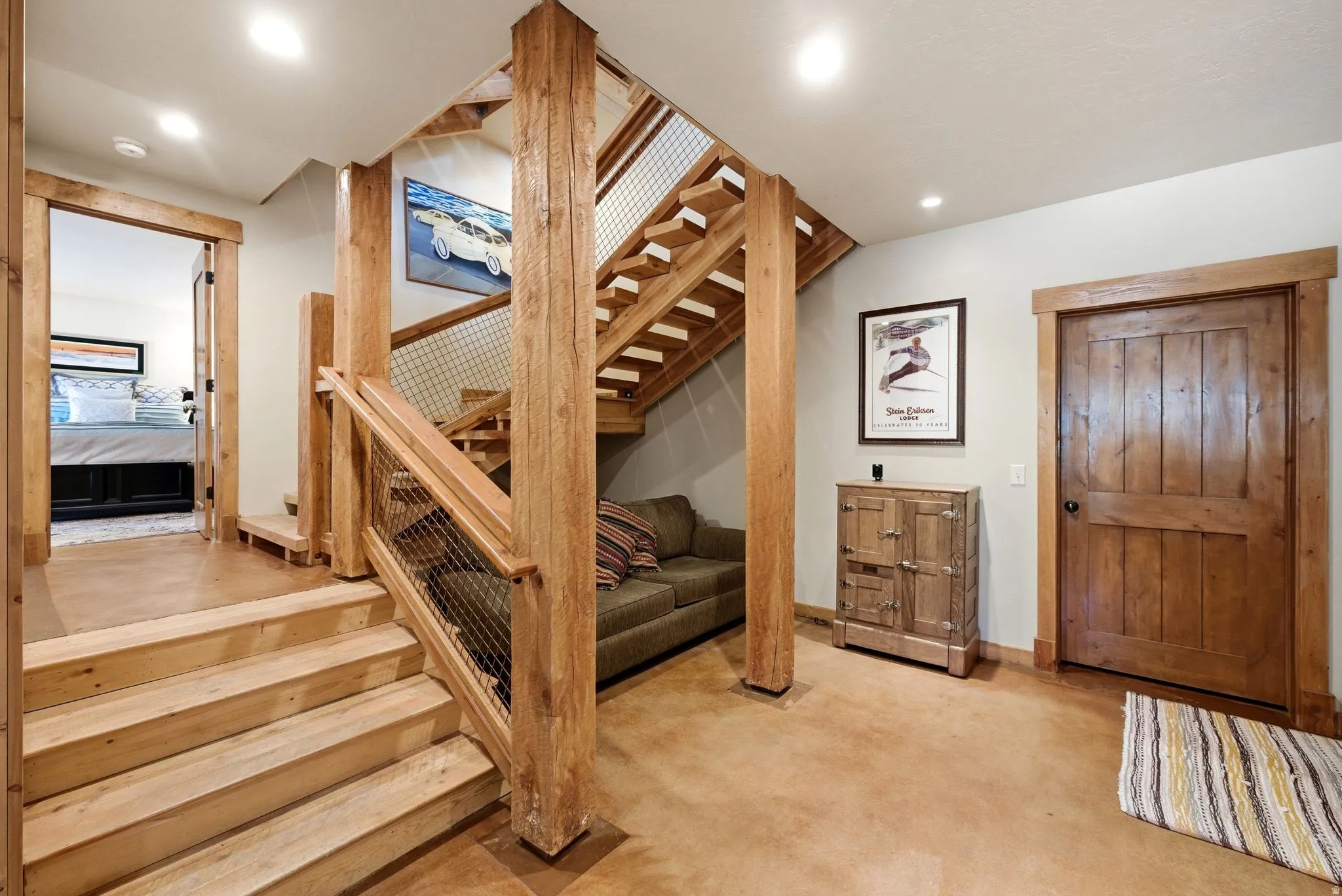 Wood-finish staircase with metal mesh railing and solid wood newel posts
