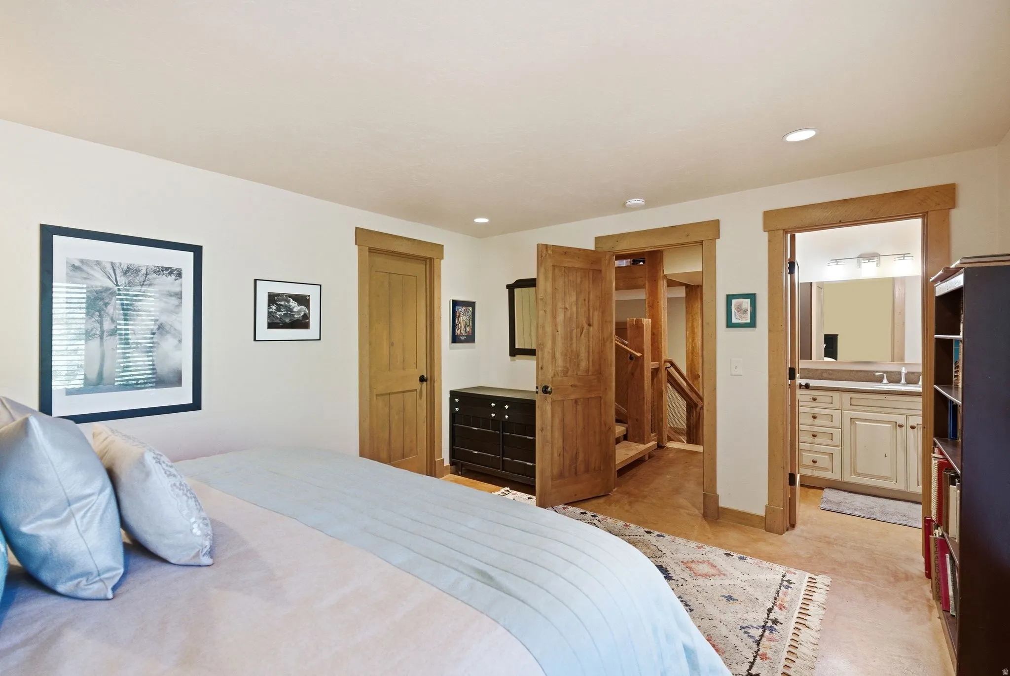 Bedroom with natural wood-finish doors and trim, recessed lighting, and light-toned walls