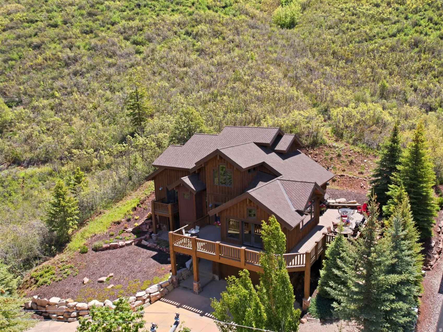 Multi-level residence featuring a brown shingle roof, extensive wood siding, and multiple balconies