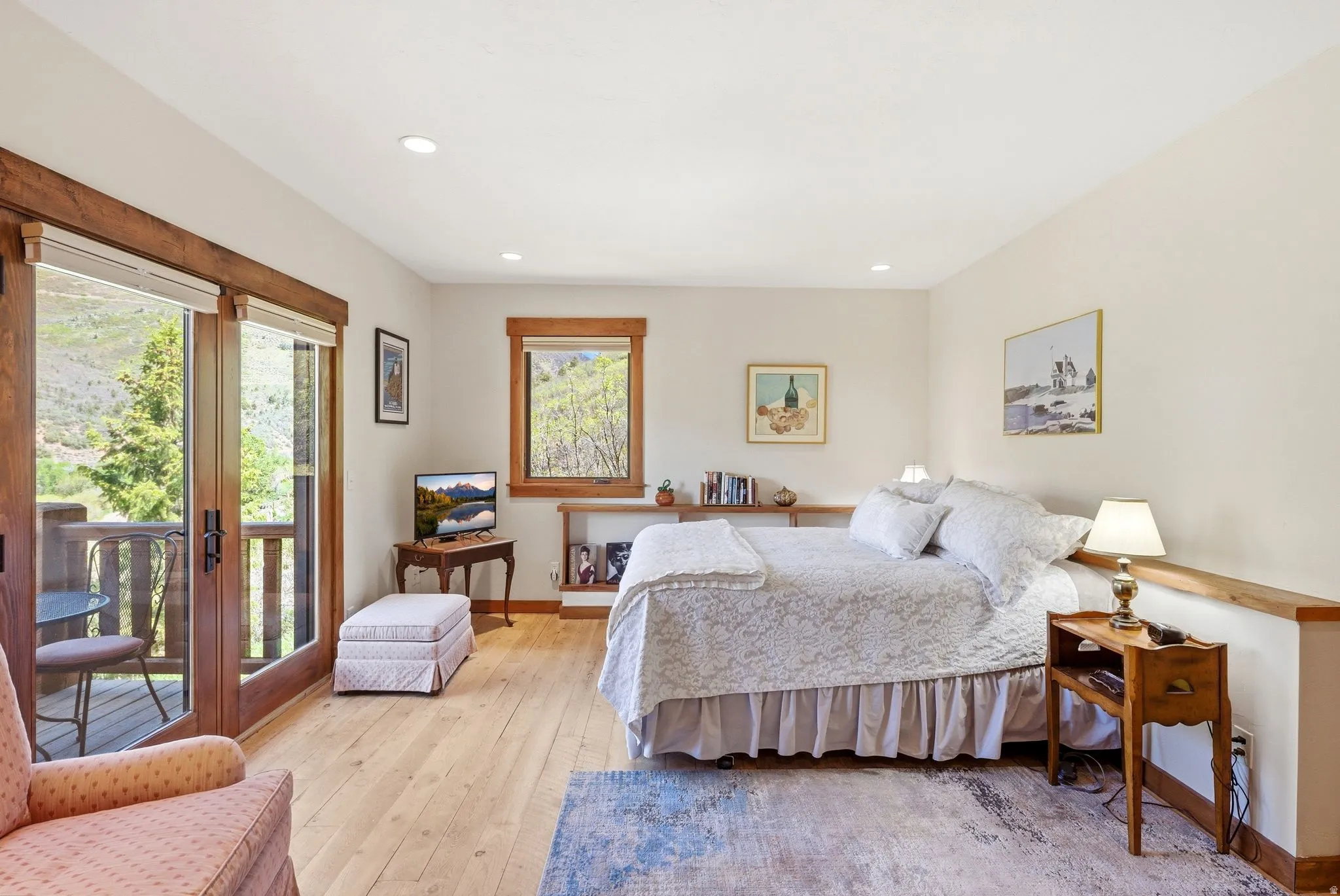 Spacious room featuring wood-finish flooring, recessed lighting, and a private balcony with double glass doors