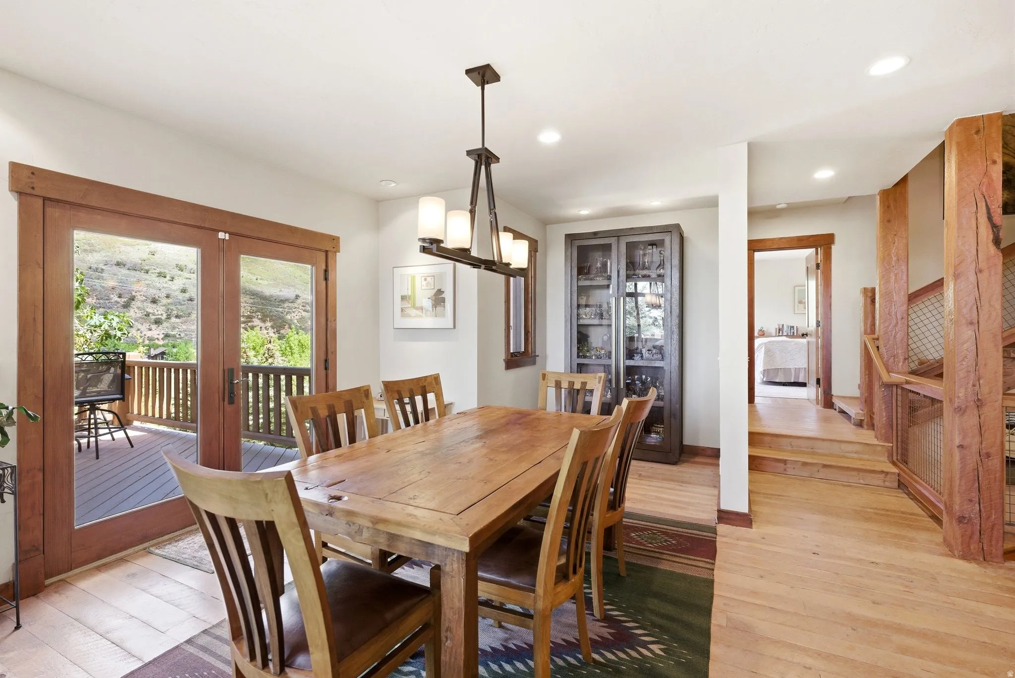 Dining area featuring wood-finish flooring, recessed lighting, and a linear chandelier