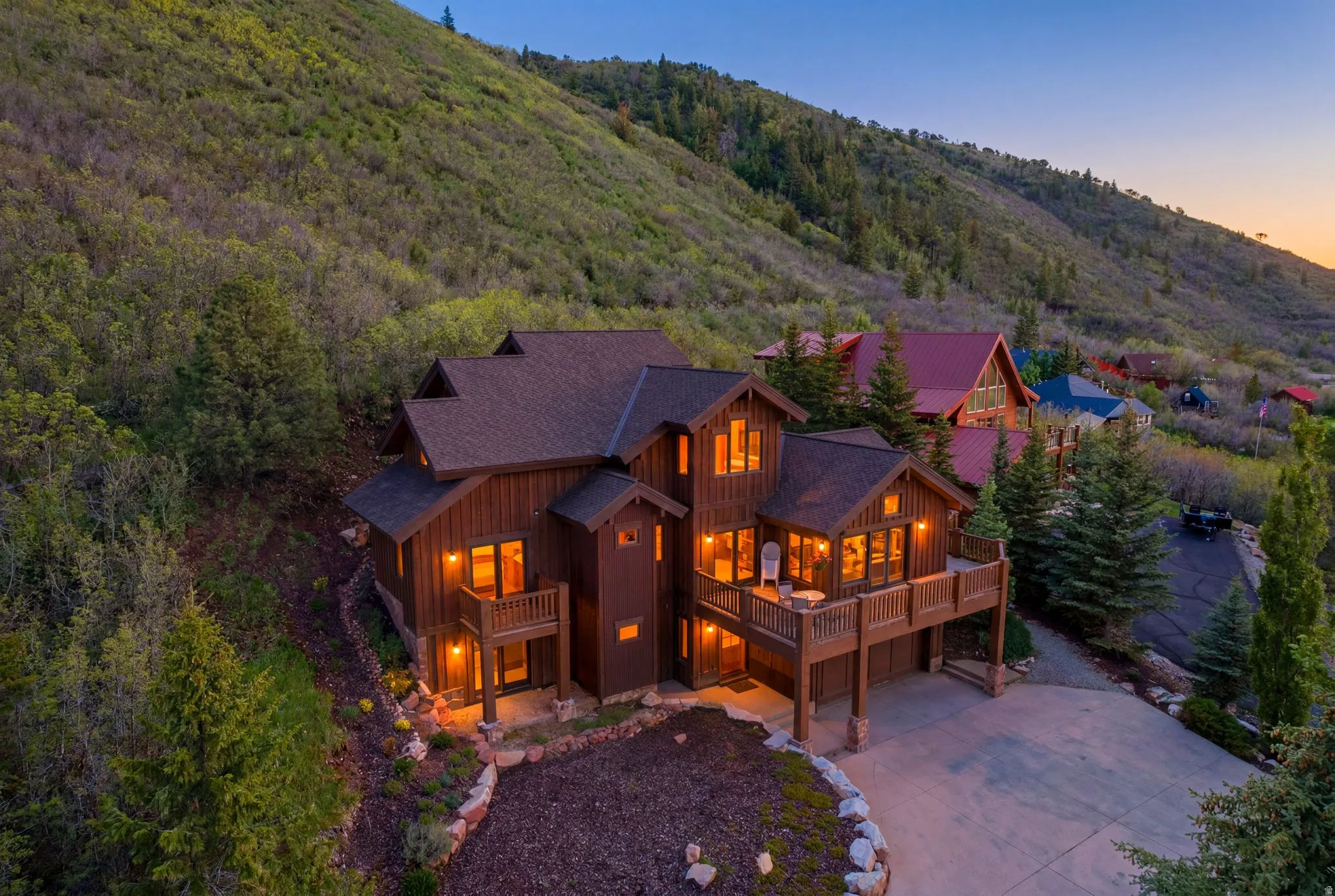 Multi-level residence featuring a dark wood-finish exterior and a dark shingle roof