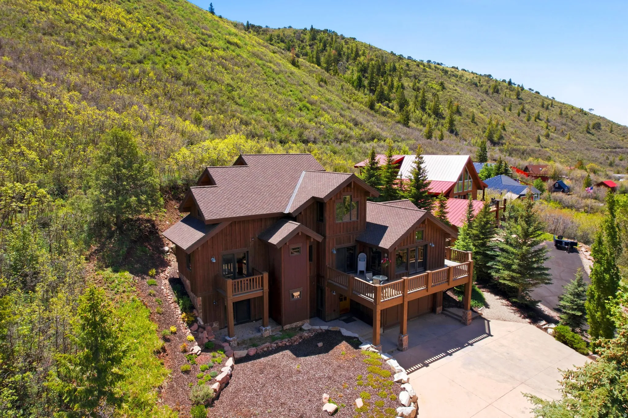 Multi-level residence featuring a brown wood-paneled exterior, dark brown shingle roof, and multiple outdoor deck spaces