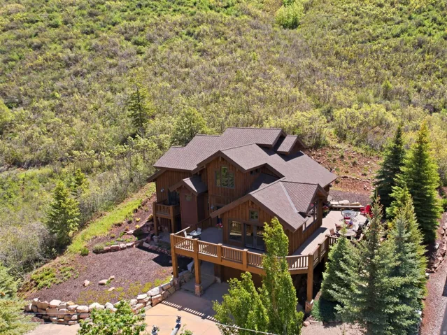 Multi-level residence featuring a brown shingle roof, extensive wood siding, and multiple balconies