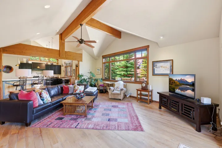Vaulted ceiling with exposed wood beams, ceiling fan, and recessed lighting