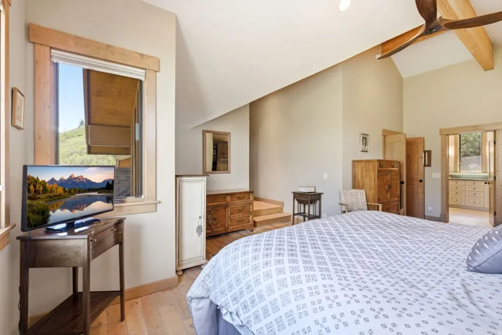Vaulted ceiling with exposed wood beam and ceiling fan