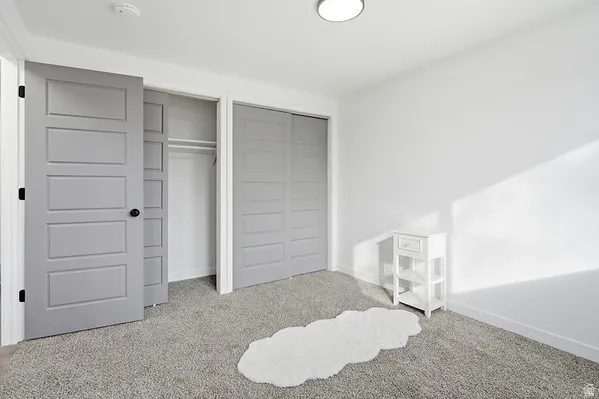 Contemporary interior featuring clean white walls, light gray carpet, and modern five-panel interior doors