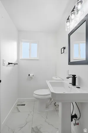 Pedestal sink with a rectangular basin and matte black faucet