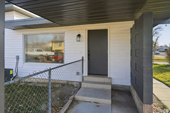 Covered porch entrance with a dark gray door and a contemporary exterior light fixture