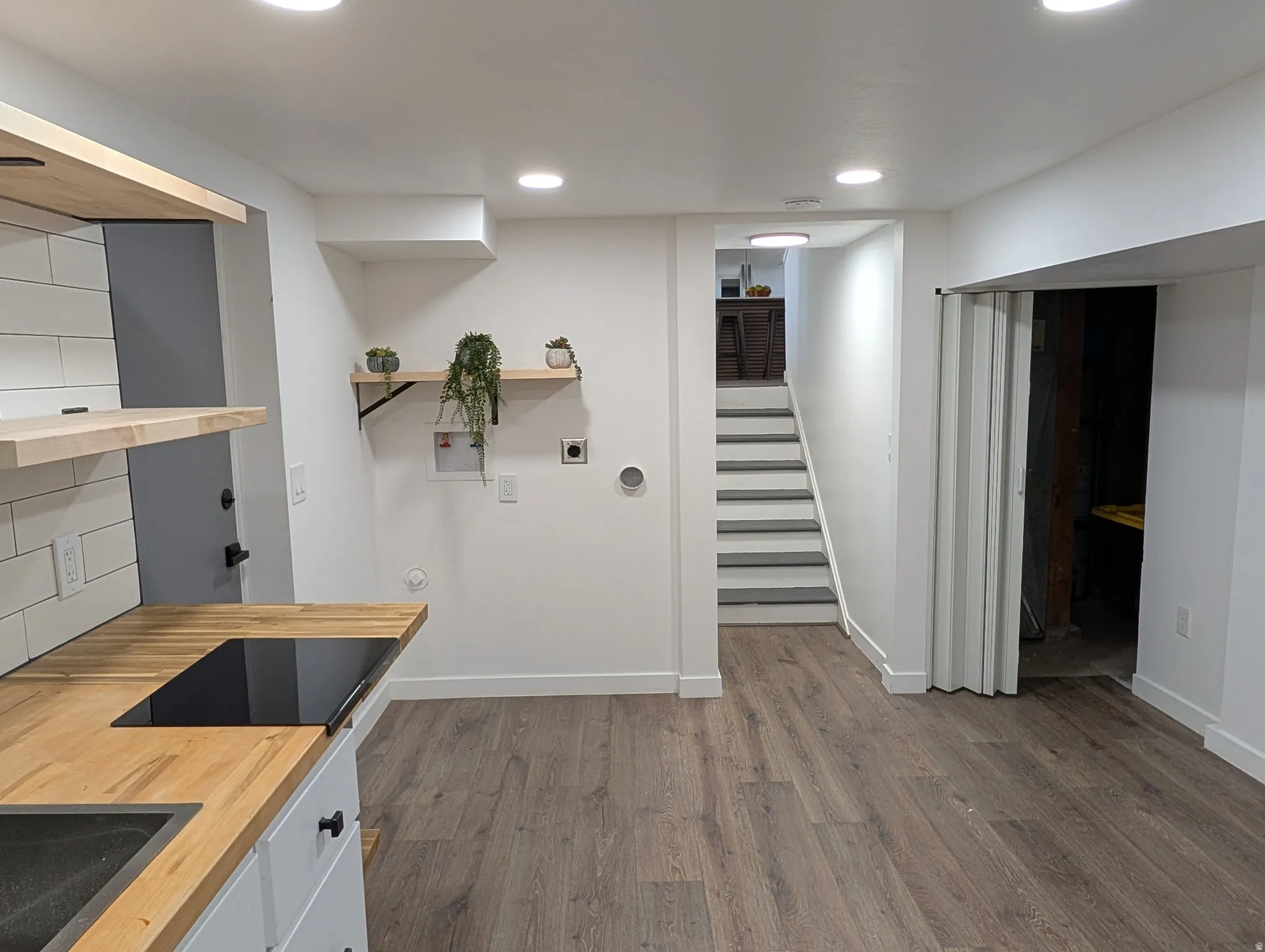 Modern kitchen area with wood-finish countertops and a black induction cooktop
