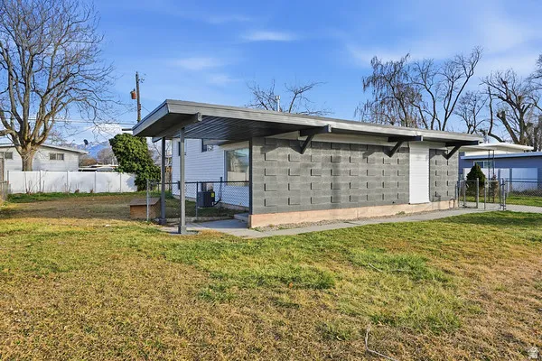 Cinder block exterior structure with a covered entry, white roll-up door, and metal awning