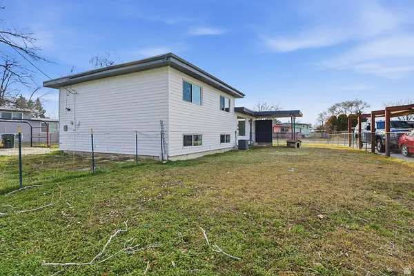 Expansive backyard featuring a partial chain link fence and a covered patio area