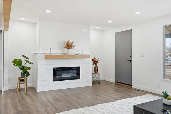 Feature fireplace with shiplap-style detailing and a natural wood mantel