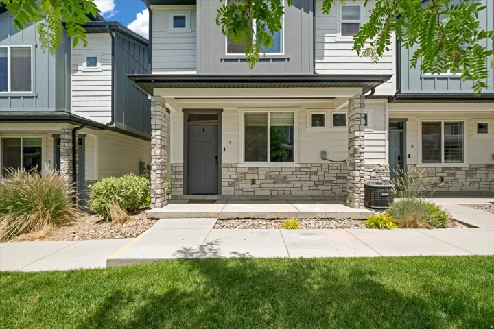 Contemporary townhouse exterior featuring a covered porch with stone veneer accents