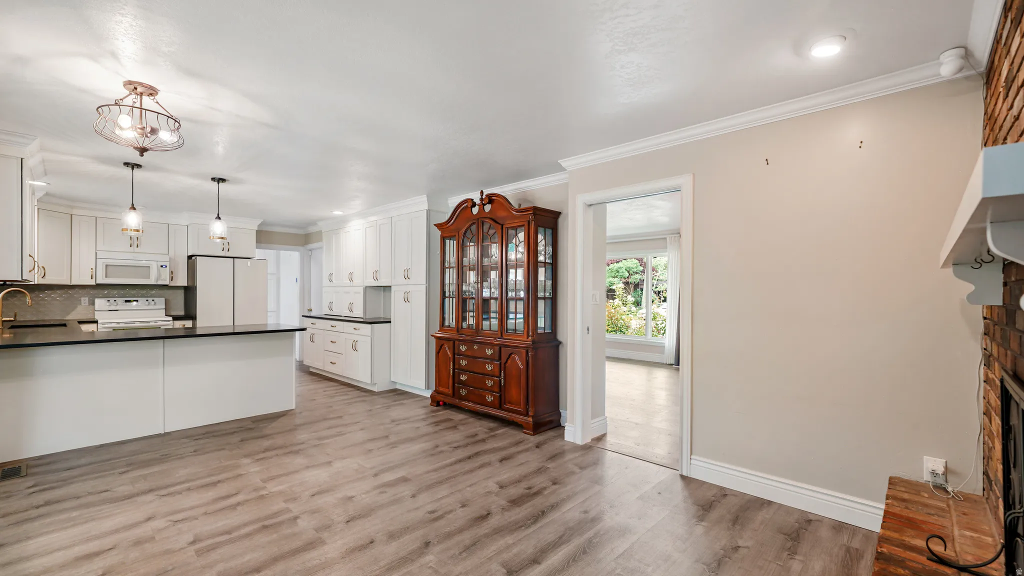 Kitchen space featuring white cabinetry, dark countertops, and stainless steel appliances