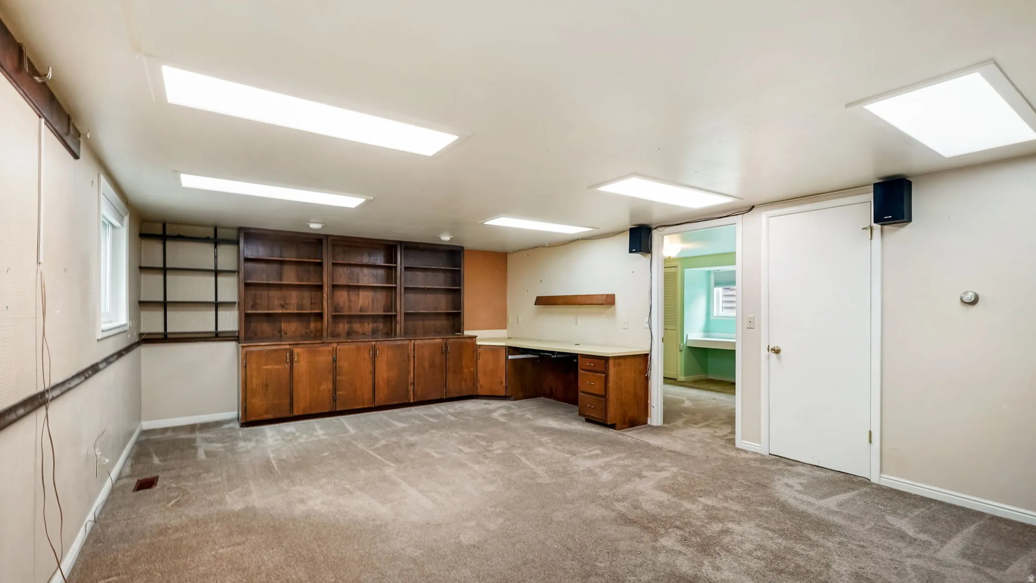 Dedicated space with built-in wood cabinetry, shelving, and a desk workstation