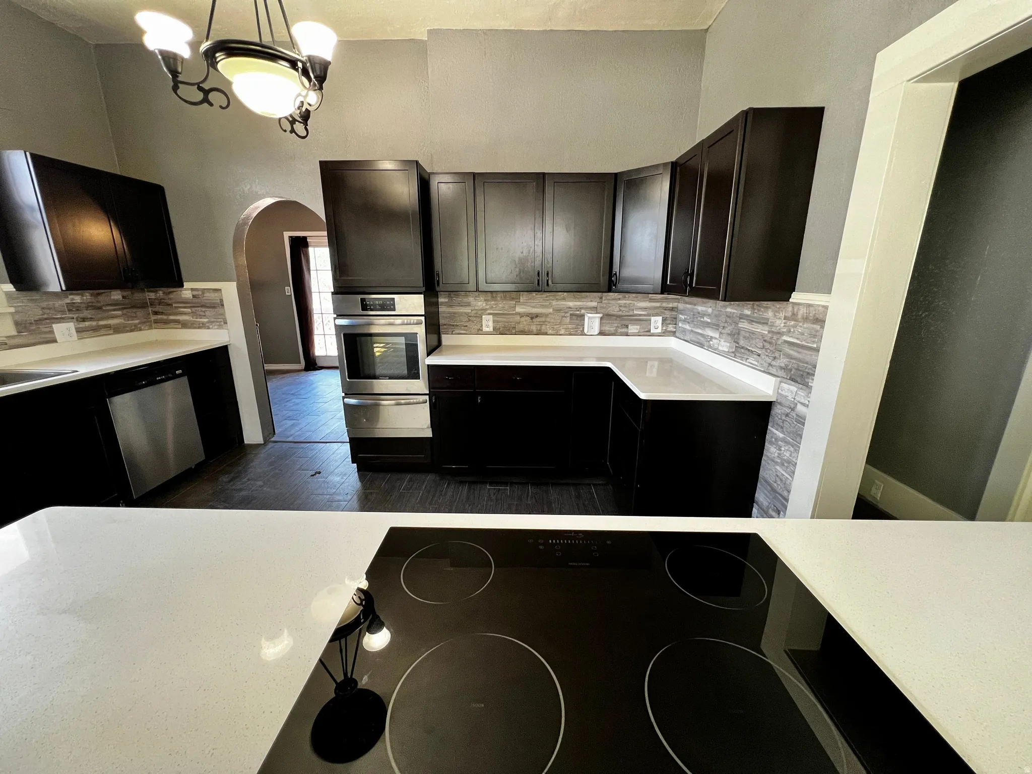Modern kitchen featuring dark wood-finish cabinetry and light-toned countertops
