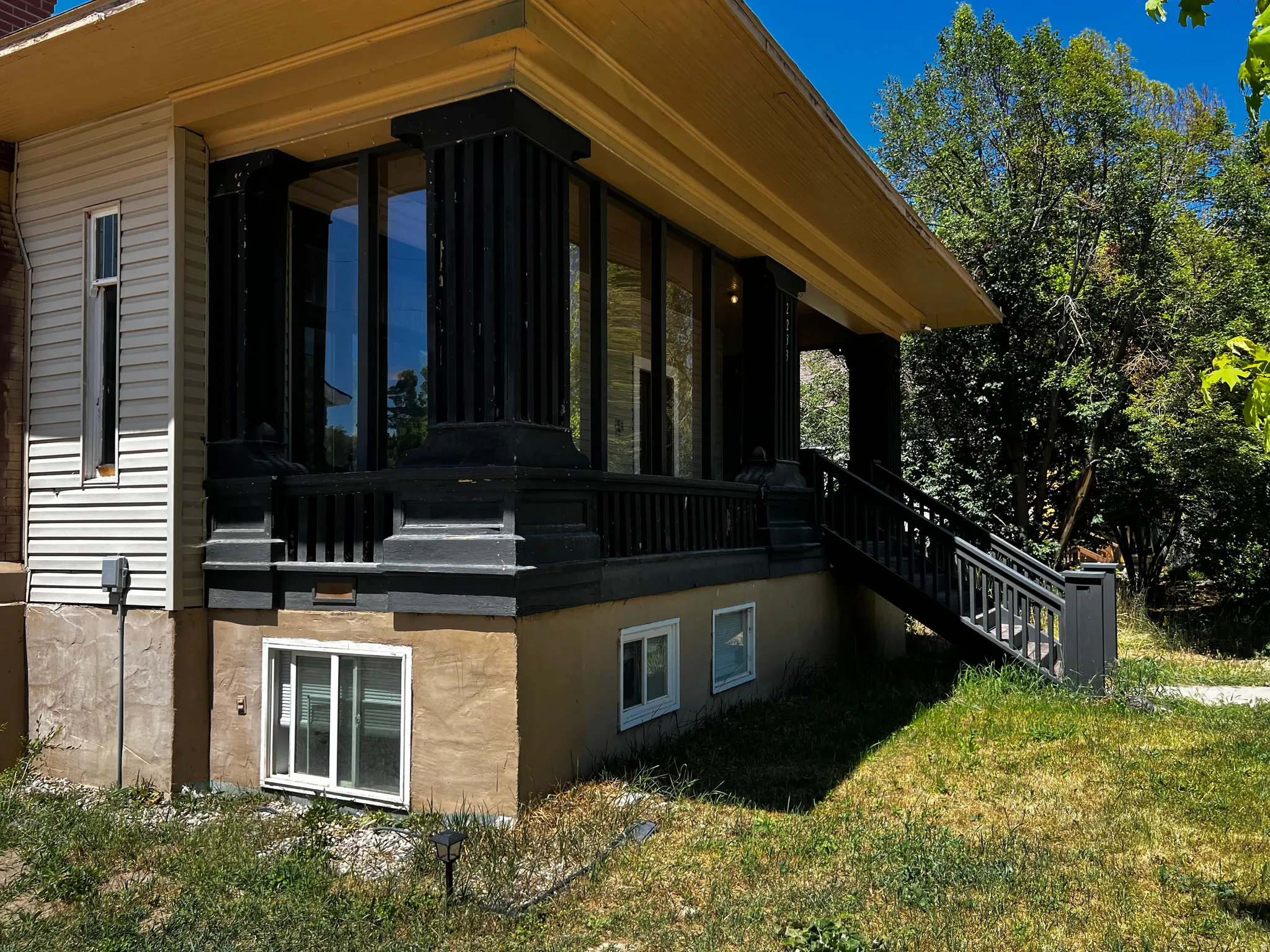 Exterior featuring a covered porch, dark fluted columns, and a railing system