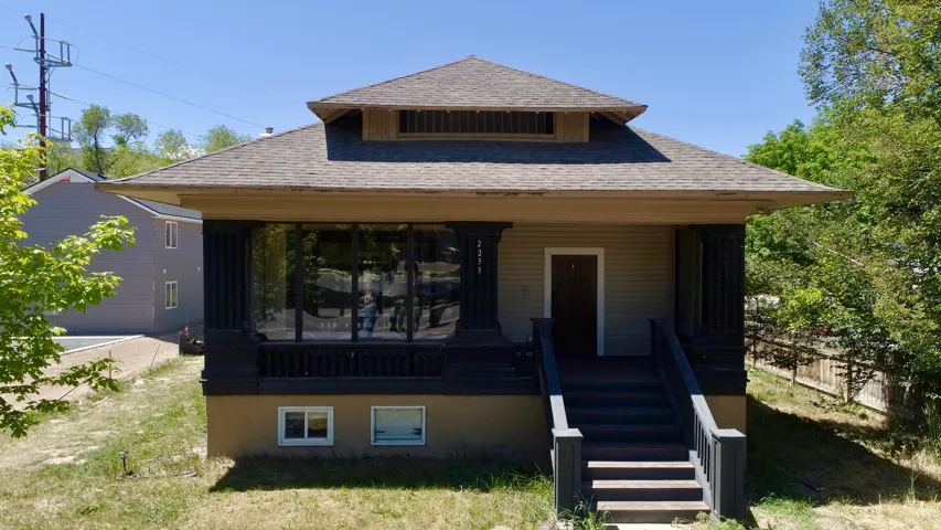 Craftsman-style home featuring a prominent front porch, shingle siding, and a hipped roof