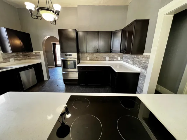 Modern kitchen featuring dark wood-finish cabinetry and light-toned countertops