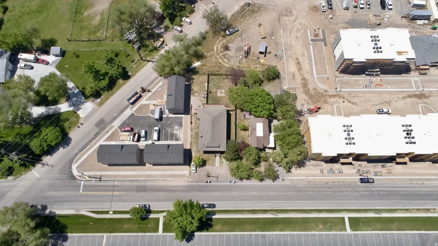Aerial perspective showcasing multiple residential structures and undeveloped land parcels