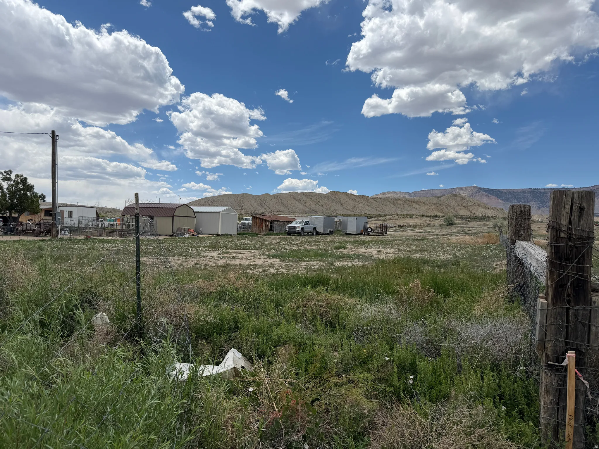 Expansive open land featuring diverse vegetation and distant mountain ranges