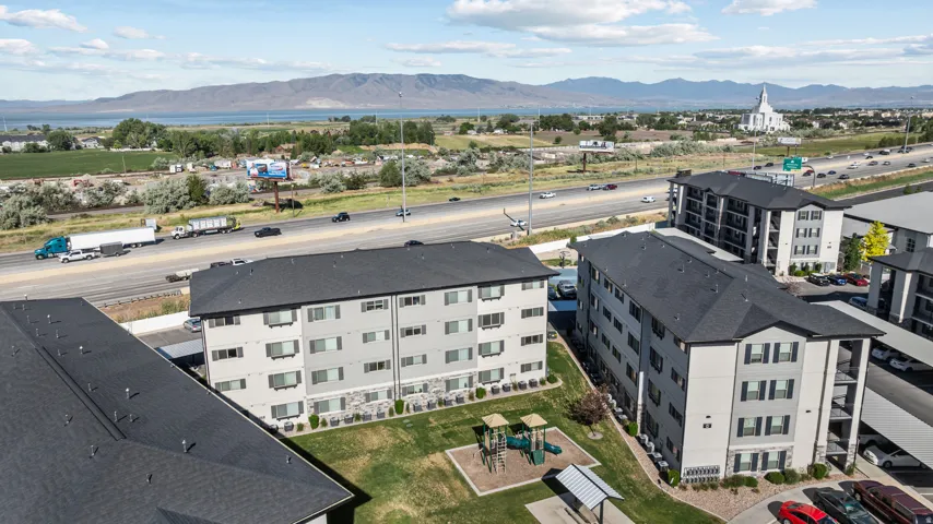 Modern multi-story apartment buildings featuring light gray siding and dark shingle roofs