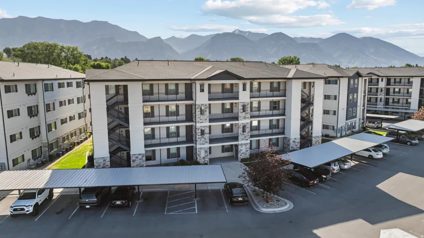 Multi-story residential buildings featuring white and gray siding with stone accents