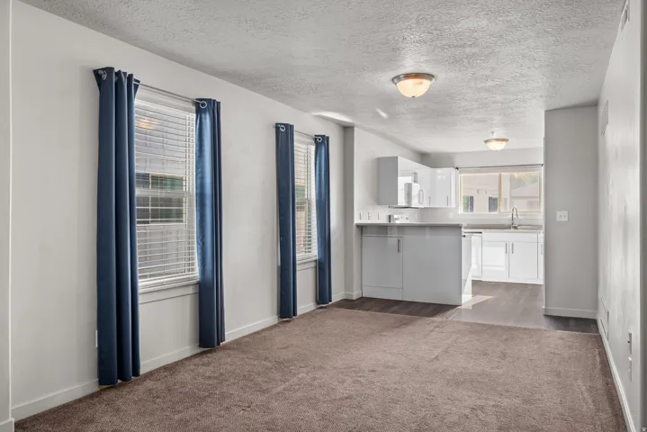 Open-concept living area featuring a kitchen with white cabinetry and a built-in breakfast bar