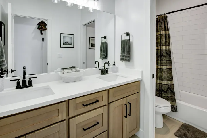 Dual vanity with wood cabinetry and matte black fixtures