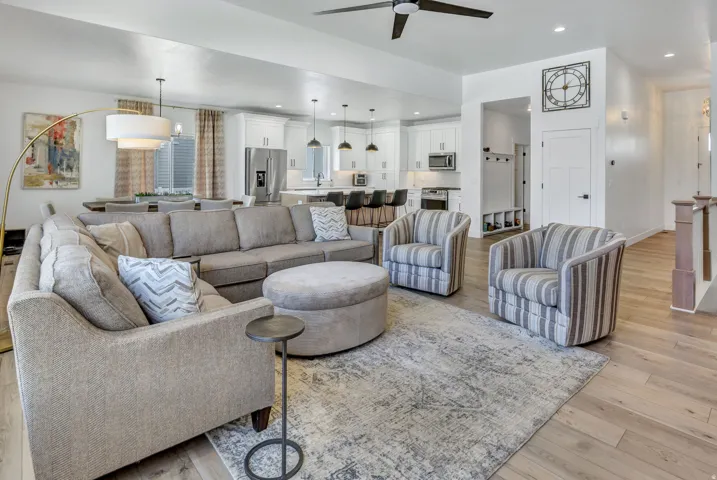 Open-concept living area featuring light LVP flooring, recessed lighting, and a contemporary ceiling fan