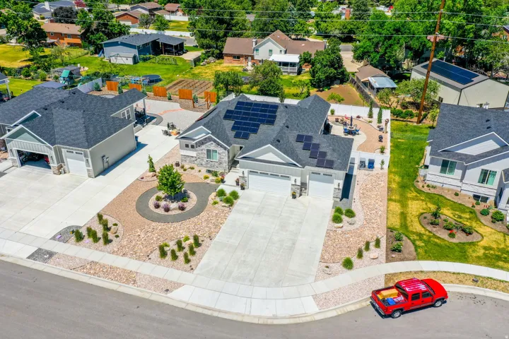 Modern residence featuring a stone and siding exterior, a multi-car driveway, and a Xeriscaped front yard with decorative plantings